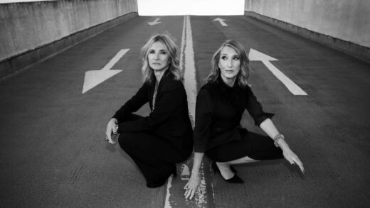 Auf dem Schwarz-weiß-Bild hocken die beiden Sängerinnen Claudia Brücken und Susanne Freytag auf einer Auffahrt zu einem Parkdeck.