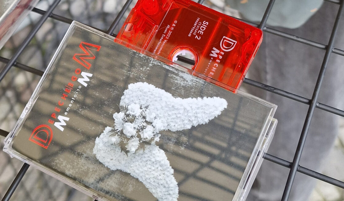 Das Bild zeigt eine rote Kassette mit dem Album "Memento Mori" von Depeche Mode